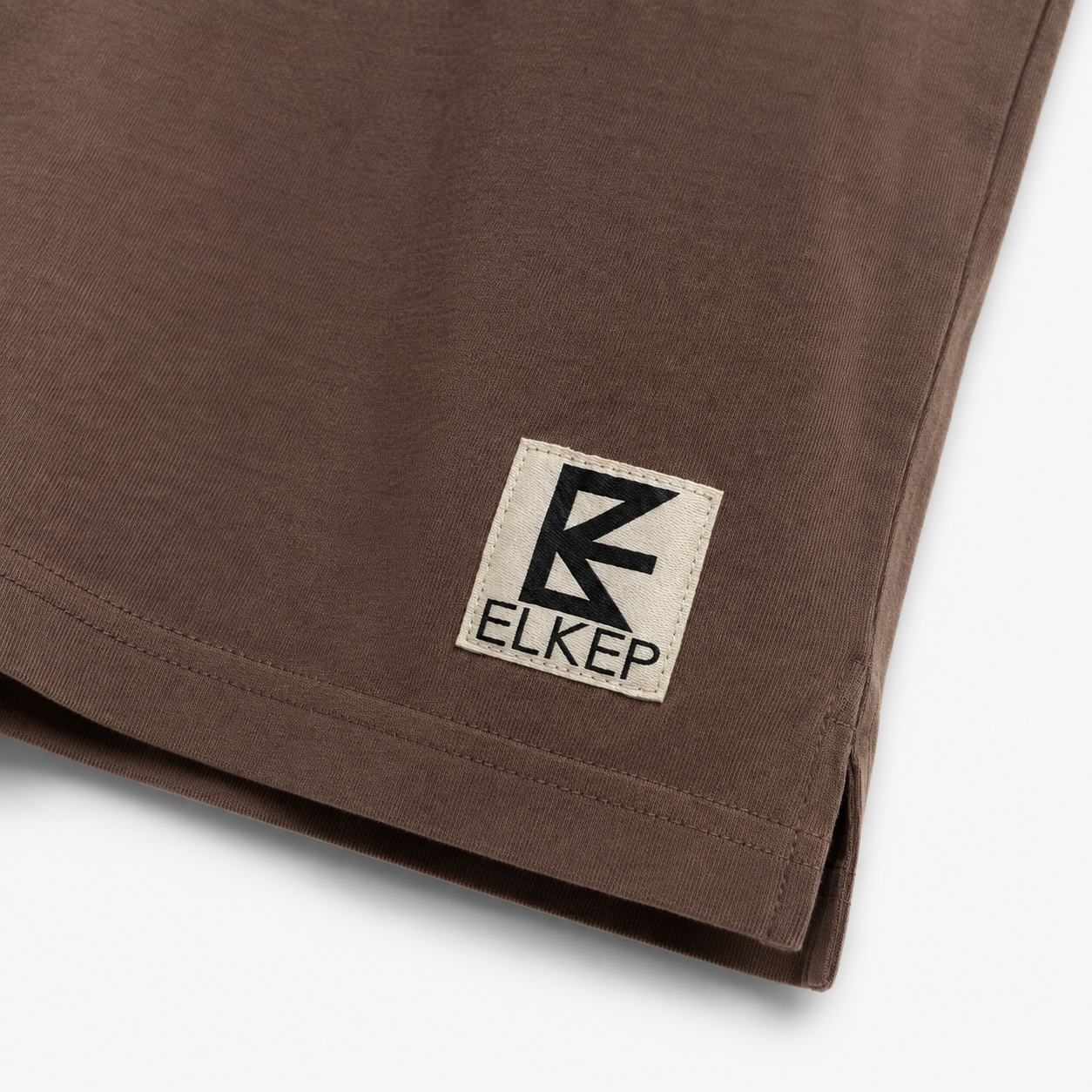 Elkep woven hem patch detail on Chocolate Heavyweight Tee